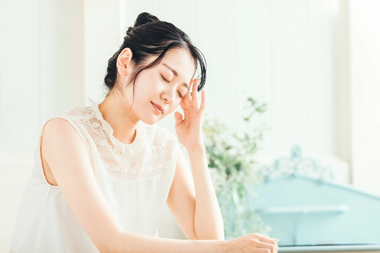 頭を押さえる女性