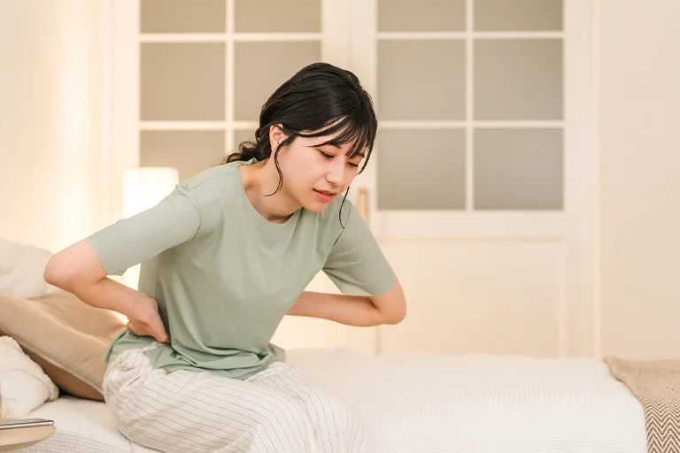脇腹を押さえて狂いそうな女性